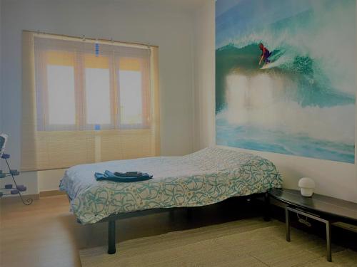 1 dormitorio con 1 cama y una pintura en la pared en AtelierSurf29 Guest House, en Almada