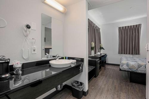 baño con lavabo y espejo grande en Motel 6-San Diego, CA - Downtown, en San Diego