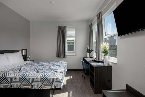 Cette chambre comprend un lit, un bureau et une fenêtre. dans l'établissement Motel 6-San Diego, CA - Downtown, à San Diego
