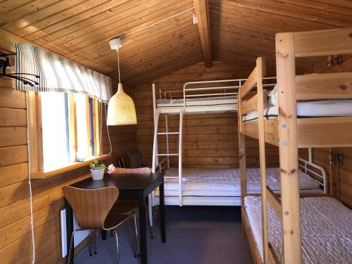 מיטה או מיטות קומותיים בחדר ב-Timber cottages with jacuzzi and sauna near lake Vänern