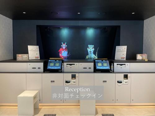 a display with two laptops on top of a counter at Henn na Hotel Komatsu Ekimae in Komatsu