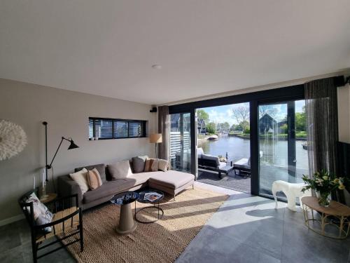 a living room with a couch and a view of the water at Villa in Balk with Private Jetty on Slotermeer in Balk