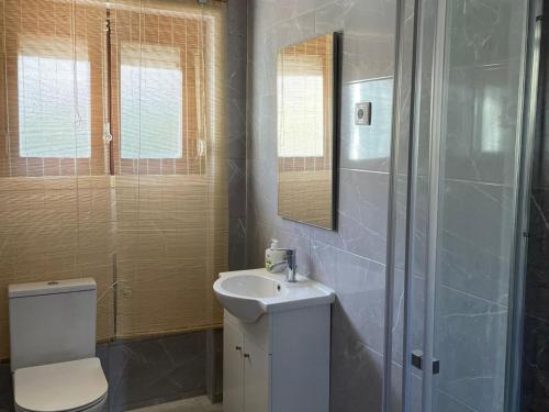 a bathroom with a toilet and a sink and a shower at AtelierSurf29 Guest House in Almada