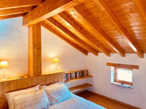 a bedroom with wooden ceilings and a bed and a window at Casinha da Praia in Carrapateira