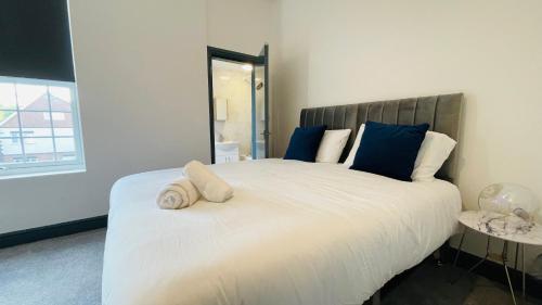 - une chambre avec un grand lit blanc et des oreillers bleus dans l'établissement YO ROOM! Apartments- Next to City Centre Apartment - With Free Parking, à Leicester