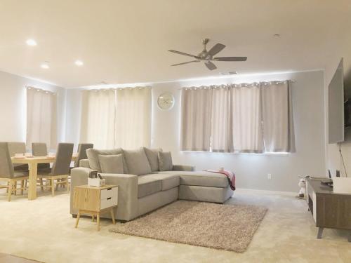 uma sala de estar com um sofá e uma ventoinha de tecto em @ Marbella Lane - 3BR Elegant House Laundry + P em Newark