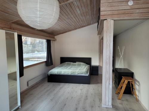 a bedroom with a bed and a large window at Svingen Apartments in Balestrand