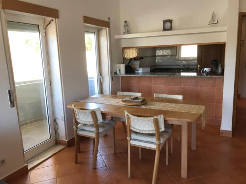 a kitchen with a wooden table and chairs and a table and a kitchen at Condo do Mar Lovely first floor apartment with pool in Lagos
