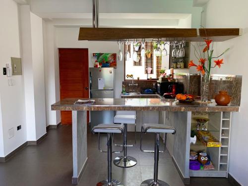 a kitchen with a large counter with stools at Depa A - Primer Piso in Cajamarca