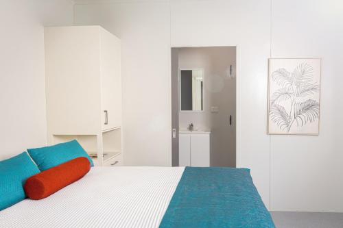 een slaapkamer met een bed met blauwe en rode kussens bij Oasis Tourist Park in Palmerston