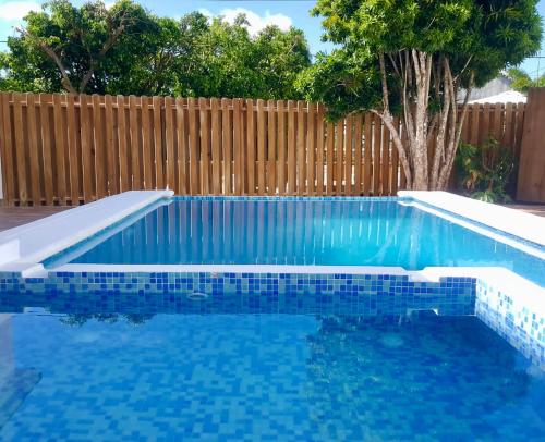 a blue swimming pool with a wooden fence at Casa Docia Hotel in Santa Bárbara de Samaná