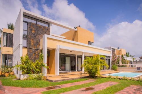 una casa con piscina frente a ella en Villa Simone: Sunlit Beach Getaway w/ Pool + WIFI, en Belle Mare