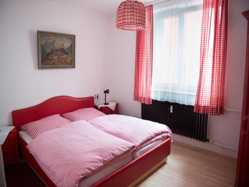 a bedroom with a red bed and a window at Hotel-Restaurant Köhler in Stuttgart