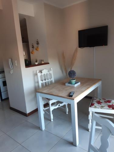 a table and chairs in a kitchen with a television at Espacio Guemes in Chivilcoy