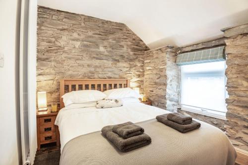 um quarto com uma cama grande e uma parede de pedra em Garreg Ddu em Blaenau-Ffestiniog
