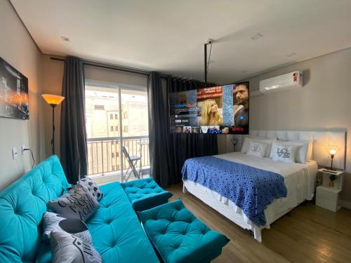 - une chambre avec un canapé bleu et un lit dans l'établissement Rover 98 Centro, à São Paulo