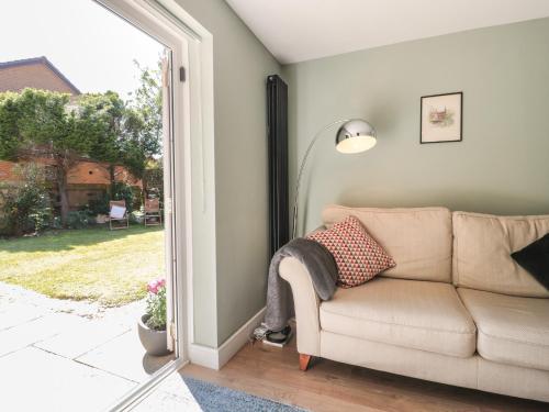 a living room with a couch and a sliding glass door at 1 Charlotte Close in Bournemouth