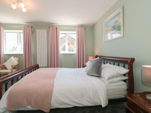 a bedroom with a bed and two windows at 1 Charlotte Close in Bournemouth