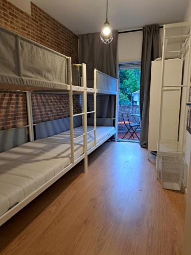 een kamer met 2 stapelbedden en een bakstenen muur bij Travel & Live Marques in Porto