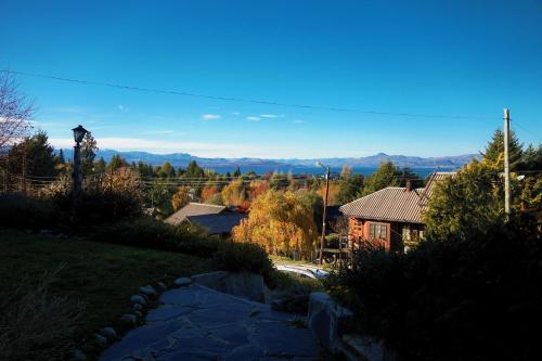 una pasarela que conduce a una casa con montañas en el fondo en Mi sueño, en San Carlos de Bariloche