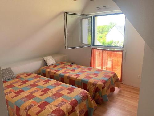 2 Betten in einem kleinen Zimmer mit Fenster in der Unterkunft Holiday Home St- Gildas-de-Rhuys - BRE04131-F in Saint-Gildas-de-Rhuys