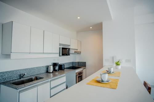 a kitchen with white cabinets and a counter top at Turek Residences in Ushuaia