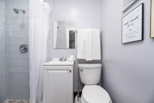 a white bathroom with a toilet and a sink at Shell on the Beach 107 - RENOVATED in Hollywood