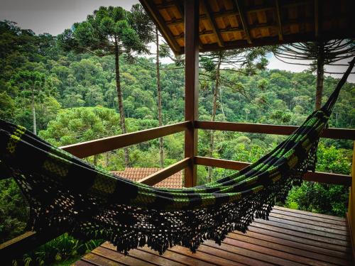 a hammock in a tree house in the forest at Pousada Toca da Onça in Gonçalves