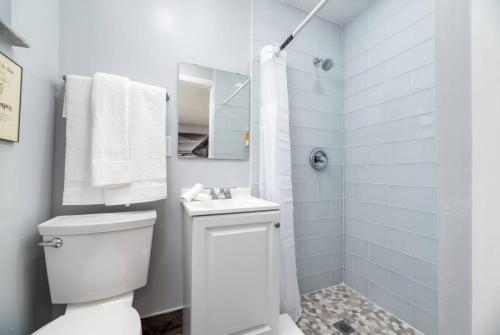 une salle de bain blanche avec toilettes et douche dans l'établissement Shell on the Beach 106 - RENOVATED, à Hollywood