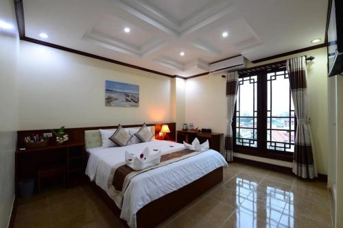 um quarto com uma cama grande e uma janela grande em Vientiane Luxury Hotel em Vientiane