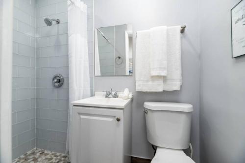 a white bathroom with a toilet and a sink at Shell on the Beach 103 - RENOVATED in Hollywood