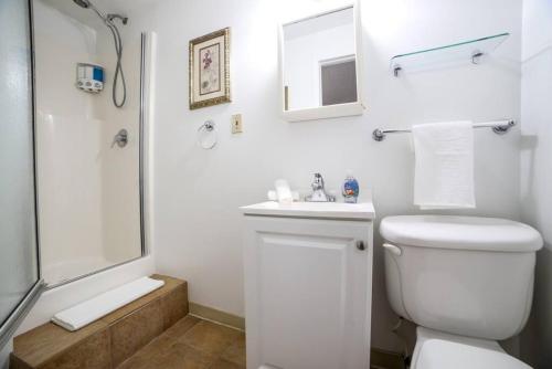 a white bathroom with a toilet and a shower at Shell on the Beach 101 in Hollywood