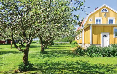 a yellow house with trees in front of it at Holiday Home Möllstorpsgatan Färjestaden in Färjestaden