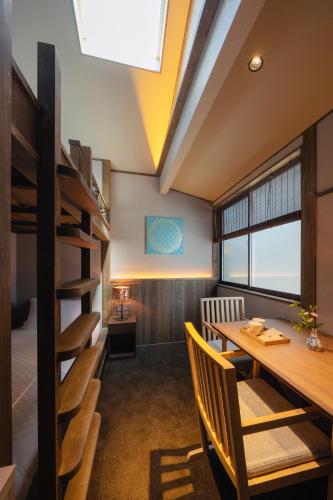 a dining room with a wooden table and chairs at THE MACHIYA KAZAHAYA in Kyoto