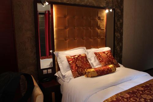 a bed with white sheets and pillows in a room at Hôtel des Buttes Chaumont in Paris