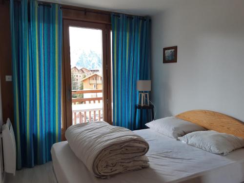 une chambre avec un lit et une grande fenêtre dans l'établissement Les Deux Alpes - Appartement 6 pers, balcon, proche pistes, wifi - FR-1-516-181, à Les Deux Alpes