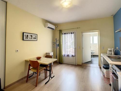 une cuisine et une salle à manger avec une table et des chaises dans l'établissement Appartement F2 climatisé avec terrasse et parking, proche des Thermes et du centre - Lamalou les Bains - FR-1-451-164, à Lamalou-les-Bains