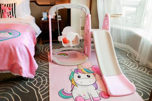 a childs bedroom with a pink bed and a unicorn crib at Wyndham Qingdao l Free Fixed-Time Shuttle Service Between Hotel and Airport & North Railway Station l Outdoor Children's Amusement Park l 1-Hour Play Snooker or Table Tennis in Qingdao