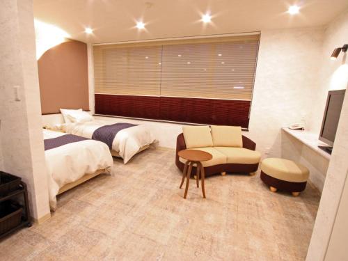 1 Schlafzimmer mit 2 Betten, einem Tisch und einem Stuhl in der Unterkunft Seiko Grand Hotel in Oga