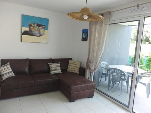 un salon avec un canapé et une table dans l'établissement Appartement 2P avec Jardin, Proche Golfe du Morbihan et Commerces, Parking Inclus - FR-1-639-67, à Sarzeau