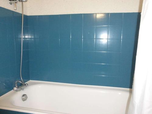 La salle de bains est pourvue d'une baignoire et d'un mur bleu. dans l'établissement Studio cabine 4 pers, parking, plage, 2 étoiles, Saint-Gilles-Croix-de-Vie - FR-1-224-791, à Saint-Gilles-Croix-de-Vie