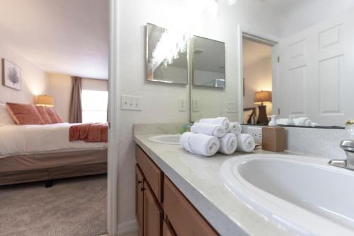 a bathroom with a tub and a sink and a bed at Romantic forest view 5BR Minutes to Disney in Kissimmee