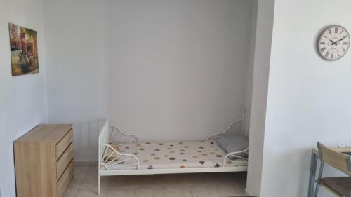a white crib in a room with a clock on the wall at Seaside appartment to enjoy,relax with great view in Gázion