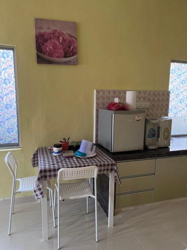 une cuisine avec une table, des chaises et un comptoir dans l'établissement SMZ Café & Homestay - SELF CHECK IN, à Kodiang