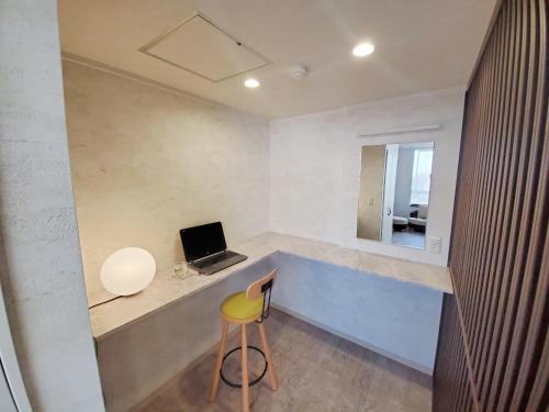 Zimmer mit einem Schreibtisch, einem Laptop und einem Stuhl in der Unterkunft Seiko Grand Hotel in Oga