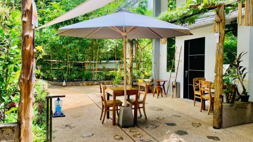 a patio with a table and an umbrella at Hidden of Cailan Inn in El Nido
