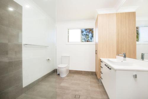 a bathroom with a white sink and a toilet at Nautilus Pet Friendly 5 Mins Walk to Bay in Callala Bay