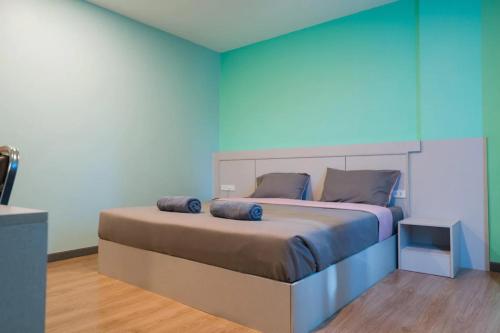 a bedroom with a large bed with a blue wall at Sritrang Residence in Ban Khlong Wa