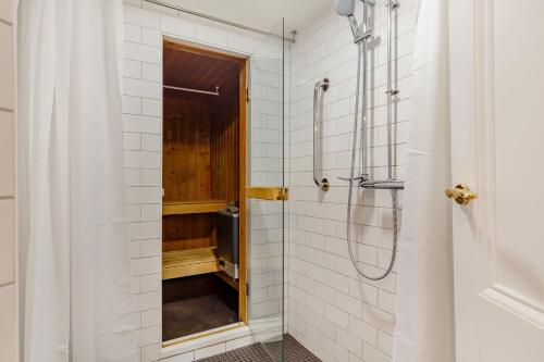 a bathroom with a shower with white tiles at The Old Chapel in Camborne
