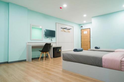 a bedroom with a bed and a desk with a chair at Sritrang Residence in Ban Khlong Wa